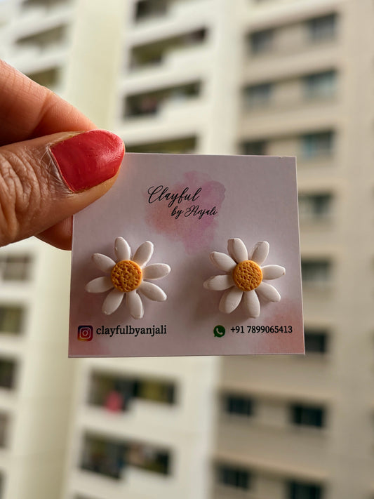 a card with daisy flower-shaped earrings