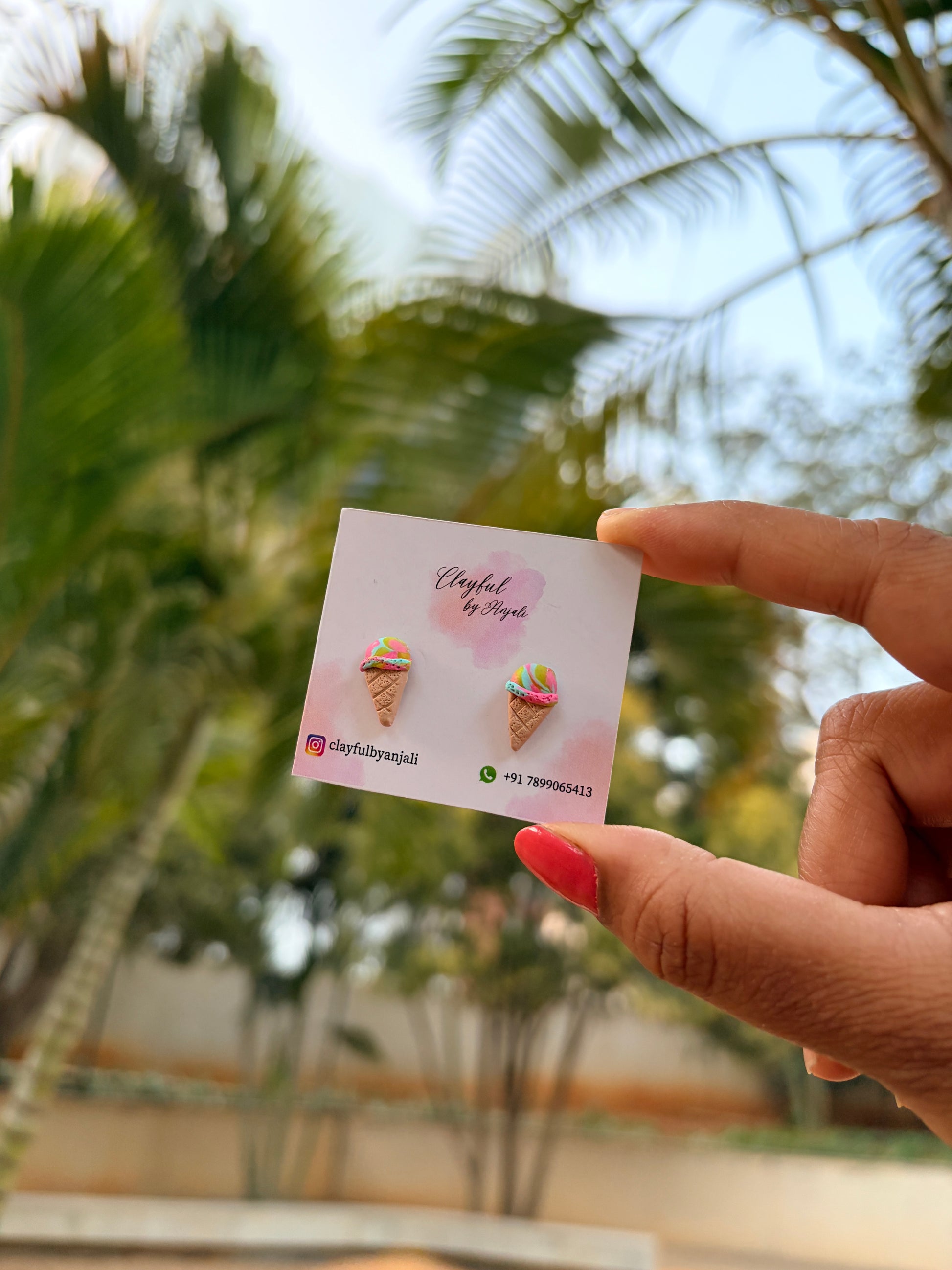 ice cream studs held against a blurred green outdoor background